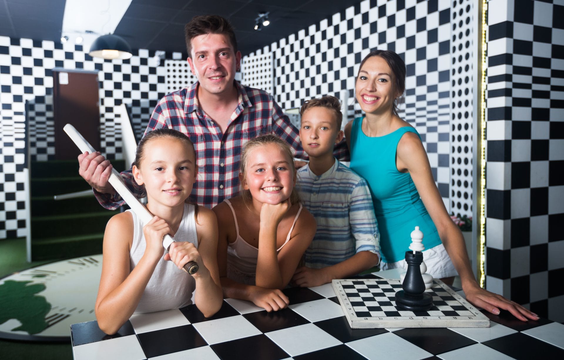 A family working together to solve a puzzle in a home escape room